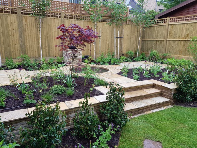 Stone paving laid by Shoots & Leaves across a garden terrace